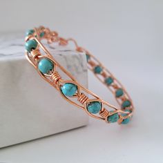 a close up of a bracelet with turquoise stones on the front and back of it