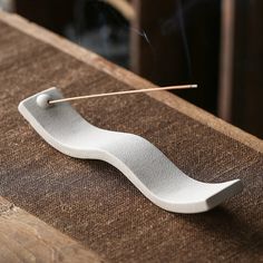 a white incense stick sitting on top of a wooden table