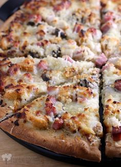 a pizza that is sitting on top of a wooden table with slices taken out of it