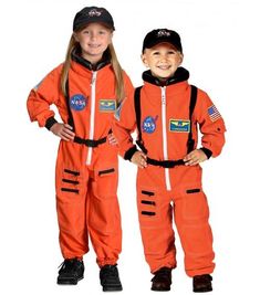 two children in orange spacesuits standing next to each other with their hands on their hips