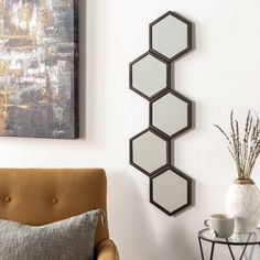 a living room filled with furniture next to a wall mounted mirror on the side of a wall