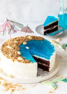 there is a cake with blue icing and an umbrella on the top of it