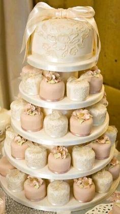 a wedding cake with lots of cupcakes stacked on it's sides and topped with a bow