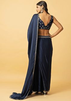 Featuring a captivating navy blue modal satin pre-draped saree with an intricately embroidered border. Teamed with a blue modal satin sleeveless blouse embellished with hand-embroidered mirror work, gota patti and zardosi floral motifs. Perfect for wedding reception or Sangeet. This saree is pre stitched saree for your convenience. Composition : Saree and Blouse - Modal satin Care: Dry Clean Only and Vacuum Storage This product can be customized for sleeves, length of blouse and neckline Delivery : 2-4 weeks as the product is hand crafted. Check Size Guide or choose MySize for free customisation (All Sizes above XL can be made at 15% additional cost) For more information and sizes please contact fabiliciousfashion@gmail.com or visit our Copenhagen studio. About the Designer : From being a Blouse Modal, Pre Draped Saree, Pre Stitched Saree, Stitched Saree, Draped Saree, Saree And Blouse, Vacuum Storage, Drape Saree, Indian Wedding Wear