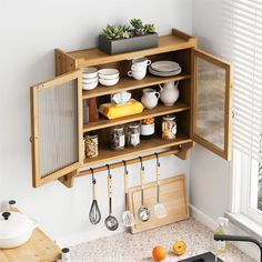 a kitchen with wooden cabinets and utensils hanging from the wall