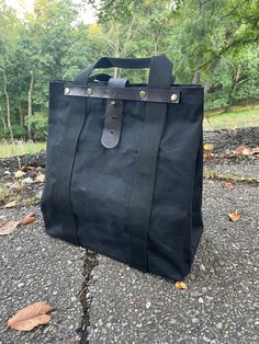 Black waxed canvas tote bag (12.5" x 14" x 7") Polyester straps (1.5") Leather bottom and supports for handle straps. Black Canvas Bag With Canvas Lining For Travel, Waxed Canvas Shoulder Bag With Double Handle, Black Canvas Bag For Travel With Canvas Lining, Black Travel Canvas Bag With Canvas Lining, Canvas Bags With Top Carry Handle For Outdoor, Black Canvas Bag For Travel, Black Double Handle Bag With Canvas Lining, Travel Shoulder Bag With Reinforced Handles In Waxed Canvas, Outdoor Canvas Bag With Top Carry Handle