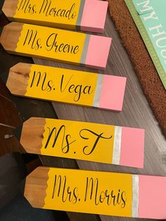 three pencils with name tags on them sitting next to a sign that says miss, mr, and mrs