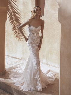 a woman in a white wedding dress standing on steps with her hand on her hip