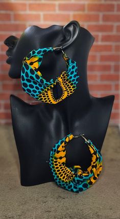 These fabric hoop earrings are lightweight and feature vibrant colors that will compliment your fashion aesthetic. Fabric Hoop Earrings, Africa Jewelry, Moda Afro, African Print Shirt, Unique Earring, African Crafts, Mixed Media Jewelry, Abstract Earrings, African Earrings