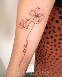 a woman's arm with a single flower tattoo on the left side of her arm