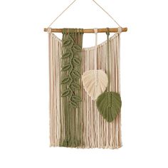 a green and white wall hanging with leaves