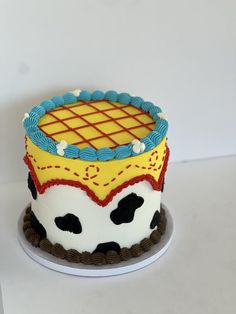 a birthday cake decorated to look like a cowgirl's head with blue, yellow and red icing