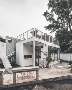 a white house sitting on top of a lush green field