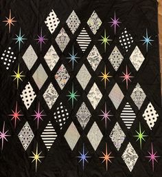 a black quilt with stars and diamonds on it