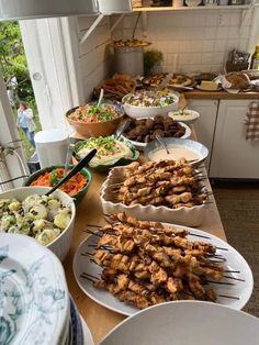 a table filled with lots of food on top of plates and pans next to each other