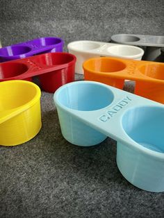 there are many different colored bowls and spoons on the floor with each one's own name