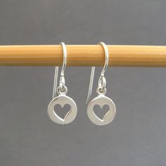 tiny silver heart earrings. sterling silver dangles. cut out hearts. everyday jewelry. small drop earrings. simple gift for her. mothers day Sweet tiny circles with heart cut outs, paired with a simple hook ear wire....great earrings for every day. - Sterling silver circles with Sterling Silver Heart Earrings With Lever Back, Cute Silver Heart Earrings In Sterling Silver, Cute Silver Sterling Heart Earrings, Dainty Sterling Silver Heart Charm Earrings, Tiny Sterling Silver Heart Earrings For Everyday Wear, Cute Sterling Silver Heart Charm Earrings, Cute Sterling Silver Heart Earrings With Charm, Drop Earrings Simple, Sterling Silver Heart Earrings