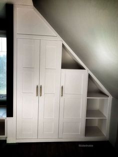 an attic bedroom with built - in storage units