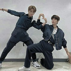 two young men are doing karate moves in front of a white wall and carpeted floor