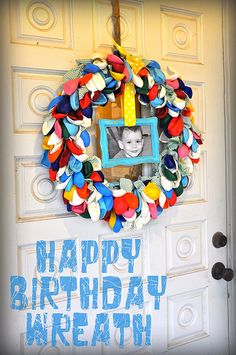 a happy birthday wreath hanging on the front door with an image of a child's face