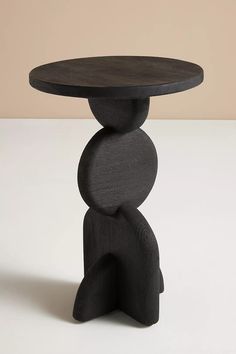 a wooden table with two stacked rocks on it's top and one sitting in the middle