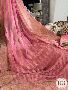 Indulge in luxury and elegance with our Banarasi Khaddi georgette saree in beautiful pink stripes. Handcrafted with intricate details, this saree exudes exclusivity and sophistication. Perfect for any occasion, this saree elevates your style and adds a touch of glamour to your wardrobe. Saree comes with a blouse piece. Fall and pico done. Fully stitched blouse shown in pictures is optional and can be purchased seperately from our blouses and croptops section. For saree video please connect with us on whatsapp @469-937-0606 Ready to be shipped in USA from San Diego, California. All pictures are original pictures. Colors may slightly vary due to pic resolution. Festival Georgette Pre-draped Saree With Border, Elegant Pink Chanderi Saree, Elegant Pink Pre-draped Saree With Zari Weaving, Elegant Pink Blouse Piece With Zari Weaving, Elegant Pink Saree For Diwali, Elegant Pink Traditional Wear With Zari Weaving, Elegant Pink Banarasi Silk Saree, Pink Saree With Sheer Dupatta For Eid, Elegant Pink Pre-draped Saree For Festivals