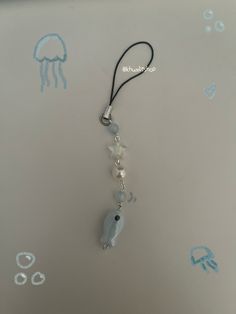 a necklace that is on top of a table with jellyfishs drawn on it