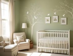 a baby's room with green walls, white furniture and pictures on the wall