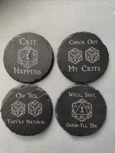 four black stone coasters with white writing on them