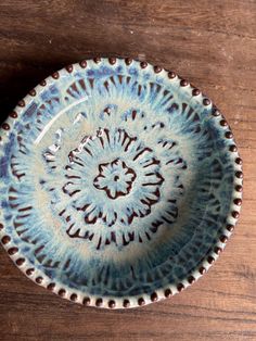 a blue and white bowl sitting on top of a wooden table