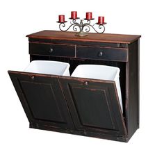 a wooden cabinet with three candles on top