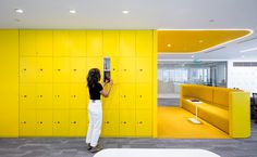 a woman standing in front of a yellow locker