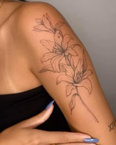 a woman's arm with a flower tattoo on the left side of her arm