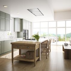 a kitchen with an island in the middle of it and lots of windows on both sides