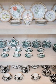 there are many plates and cups on the shelves