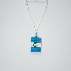 a blue and white beaded necklace on a silver chain hanging from a clipping