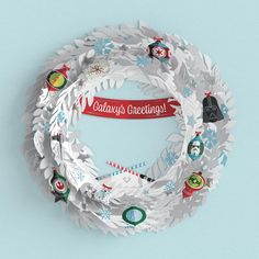 a paper wreath with the words galaxy's greetings on it, surrounded by snowflakes and christmas decorations