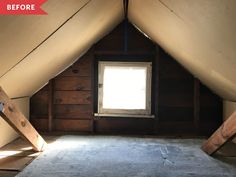 an attic with wooden walls and white window