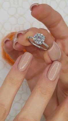 a woman's hand with a ring on it and a diamond in the middle