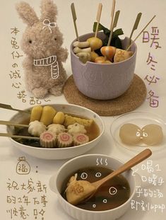 two bowls filled with food sitting on top of a table next to a stuffed animal