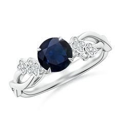 an oval blue sapphire and diamond ring with two white diamonds on the shoulders, set in 18k white gold