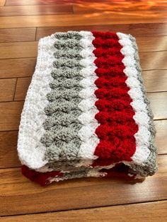 a crocheted blanket sitting on top of a wooden floor