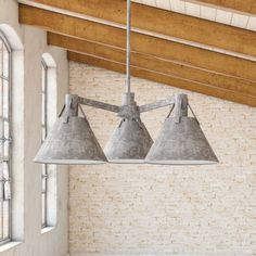 three lights hanging from the ceiling in a room with brick walls and beams on the ceiling