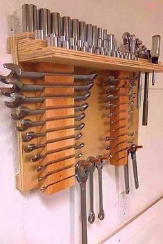 a wall mounted tool rack filled with lots of wrench's and screwdrives