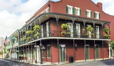 a red building with balconies and plants on the balcony