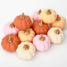 small pumpkins with gold bows on them are arranged in a pyramid formation, all different colors