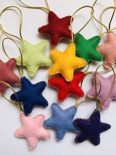 six different colored stars are hanging from gold chains