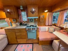 a kitchen with a stove top oven sitting next to a bed in a living room