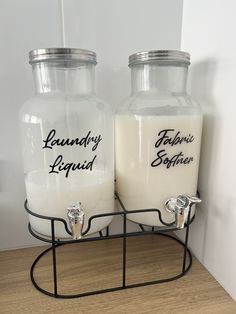 two glass jars with labels on them sitting on a wire rack next to each other