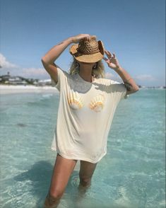 Seashell bra, seashell shirt, blue water, beach girl, summer style, Florida beach, tropical beach, paradise, seashell Beige Graphic Tee For Summer, Summer Beige Crew Neck Top, Beige Crew Neck Top For Vacation, Cream Crew Neck Top For Vacation, Beige T-shirt For Beach, Summer Season, Beige Crew Neck Top For Beach, Bohemian T-shirt For Beach With Short Sleeves, Bohemian Short Sleeve T-shirt For Beach, Beige Short Sleeve Beach Tops